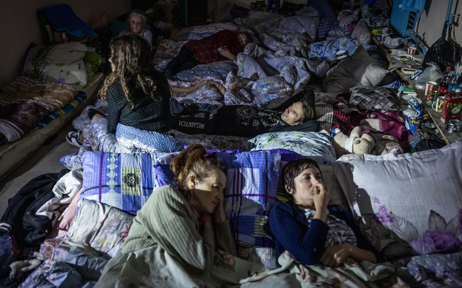 People sleep in the basement of a school being used as a bomb shelter in Sudzha.