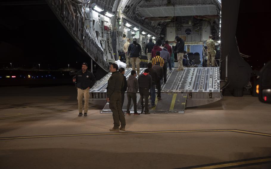 U.S. Customs and Border Protection agents load illegal immigrants onto a C-17 Globemaster III 