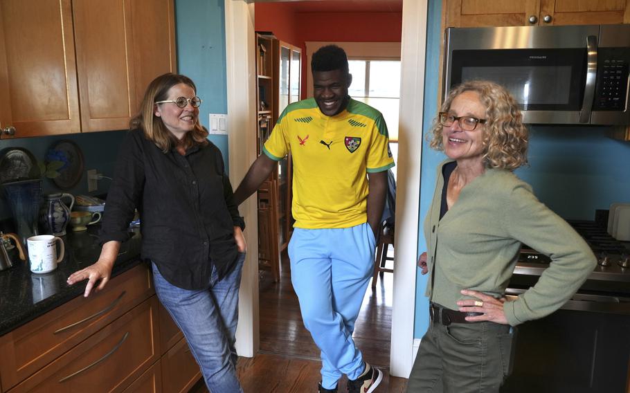 Cabrel Ngounou, center, a refugee from Cameroon, talks with his sponsors Lori Ostlund, left, and Anne Raeff in their home in San Francisco, Tuesday, Sept. 17, 2024.