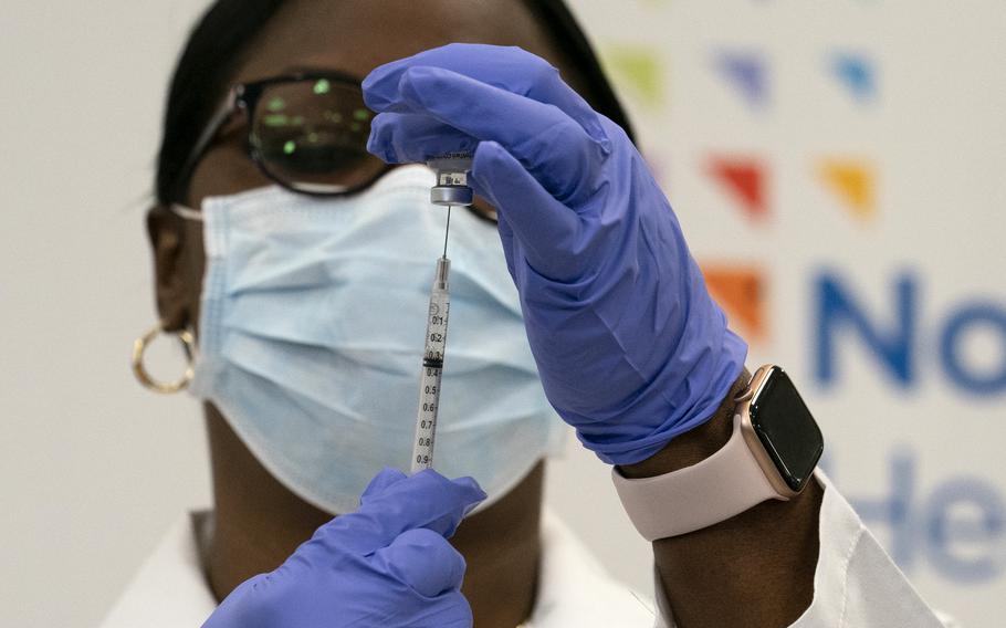 Dr. Michelle Chester draws the Pfizer-BioNTech COVID-19 vaccine into a syringe at Long Island Jewish Medical Center, Monday, Dec. 14, 2020, in the Queens borough of New York. (AP Photo/Mark Lennihan, Pool)