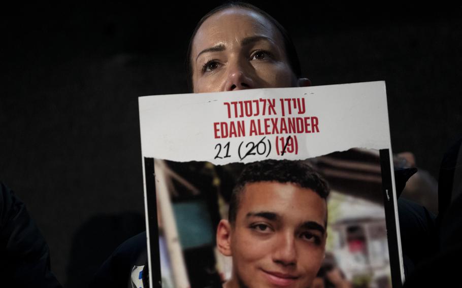 A woman holds a poster of her son who is a hostage held by Hamas militants.