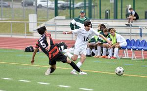 Naples freshman Finn Stephens gets fouled by American Overseas School of Rome defender MengPeng Jiang during the Division II title match at the DODEA European soccer championships on May 23, 2024, at Ramstein High School on Ramstein Air Base, Germany.