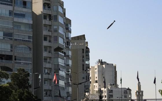 A bomb falls through the air toward a multi-story building.