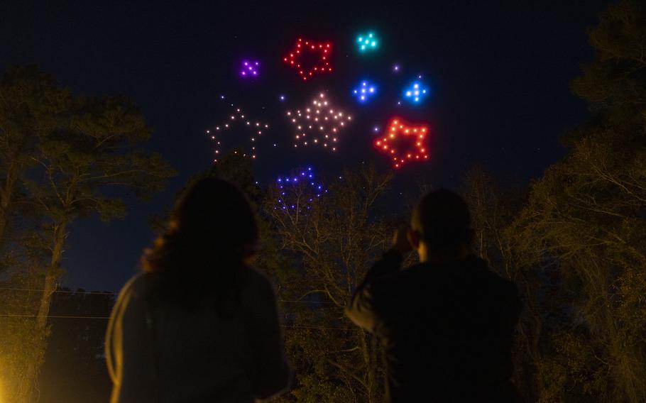 A drone show with colored stars overhead.