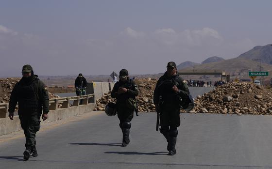 Police patrol at a roadblock in Vilaque on the outskirts of El Alto, Bolivia, Monday, Sept. 16, 2024. The roadblock was placed by protesters demanding the resignation of Bolivian President Luis Arce for his management of the economy. (AP Photo/Juan Karita)