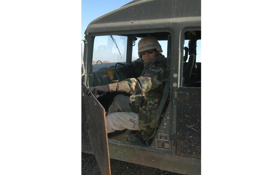 A soldier showing an Iraqi-made steel door of a Humvee