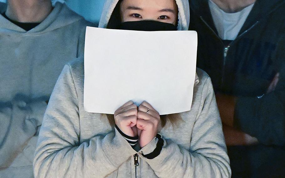 A woman joins other demonstrators on the campus of the University of California, Irvine, on Nov. 29, 2022, as they protested the deaths caused by an apartment complex fire in Urumqi, Xinjiang, China.