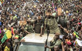 FILE - An unidentified representative of the junta waves from a military vehicle as Malians supporting the recent overthrow of President Ibrahim Boubacar Keita gathers to celebrate in the capital Bamako, Mali, on Aug. 21, 2020. The coup-hit nations of Niger, Mali and Burkina Faso were meeting on Saturday, July 6, 2024 in their first regional summit that officially sets them apart from the West Africa regional bloc after earlier announcing they were leaving the bloc. (AP Photo/File)