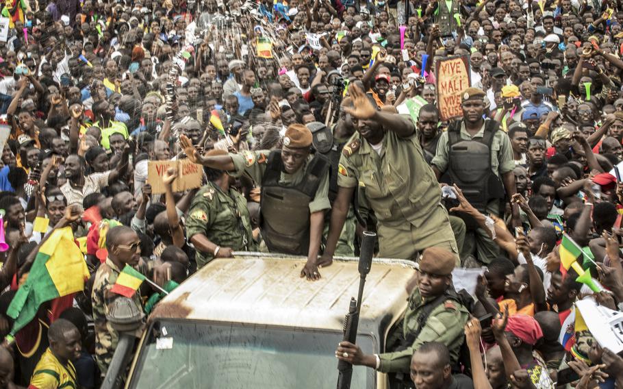 A member of Mali’s junta waives to supporters after the 2020 coup.