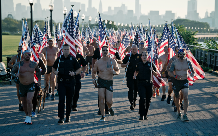 Participants carrying American flags while completing the Navy SEAL Swim.