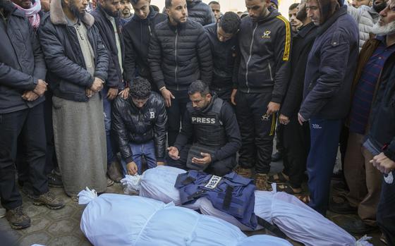 Colleagues and friends mourn over the body of freelance journalist Omar al-Derawi and other victims of overnight Israeli army strikes at multiple locations in central Gaza Strip, at Al-Aqsa Martyrs Hospital in Deir al-Balah, Friday, Jan. 3, 2025. According to Al-Aqsa Martyrs Hospital, 30 people, including 10 women and 7 children, were killed in several attacks overnight in central Gaza. (AP Photo/Abdel Kareem Hana)