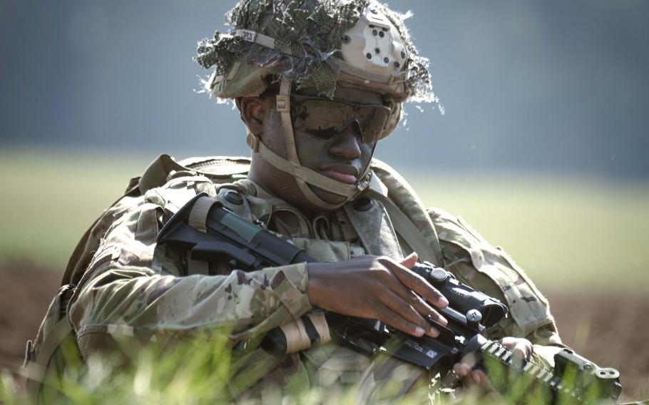 A soldier with the 173rd Airborne Brigade inspects his weapon after parachuting into a field outside of the Joint Multinational Readiness Center Hohenfels Training Area, Germany, for Exercise Saber Junction on Sept. 4, 2024. 