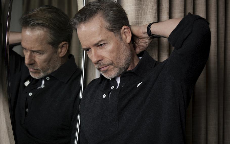 Guy Pearce posing in front of a mirror. 