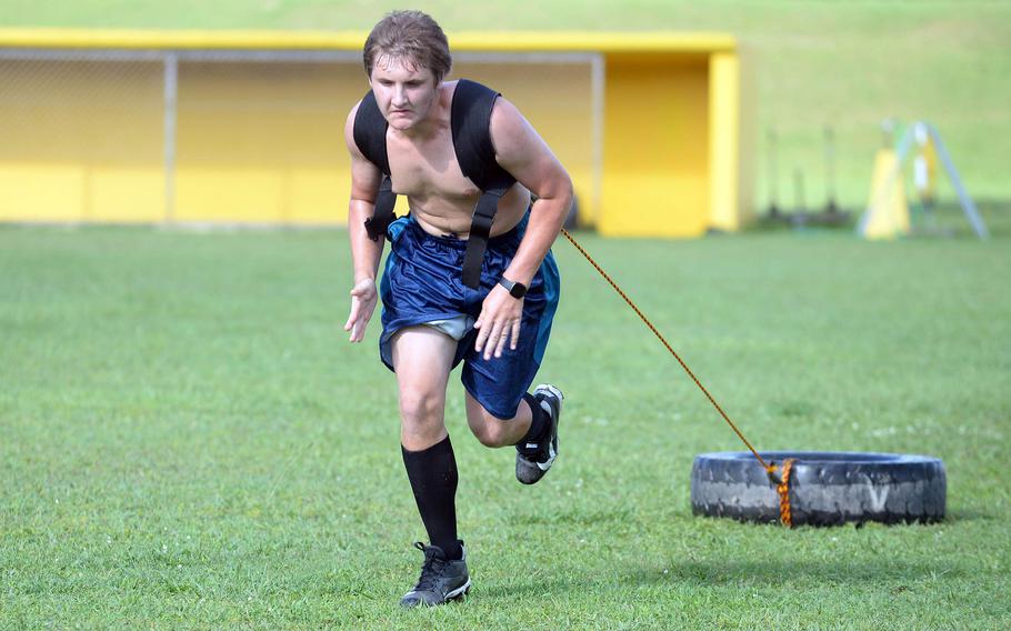 Kadena freshman Connor Shiflet pulls a tire during Monday's first Panthers football practice.