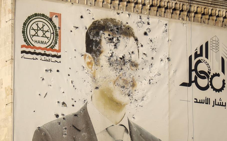 An image of Syrian President Bashar Assad, riddled with bullets, is seen on the facade of the provincial government office in the aftermath of the opposition’s takeover of Hama, Syria, Friday, Dec. 6, 2024.