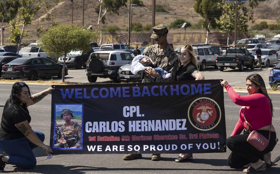 U.S. Marine Corps Cpl. Carlos Hernandez, a rifleman with Charlie Company, Battalion Landing Team 1/5, 15th Marine Expeditionary Unit, and a native of Chino Hills, Calif., holds his newborn for the first time alongside his wife at Marine Corps Base Camp Pendleton, Calif., on Aug. 10, 2024, after returning from deployment.