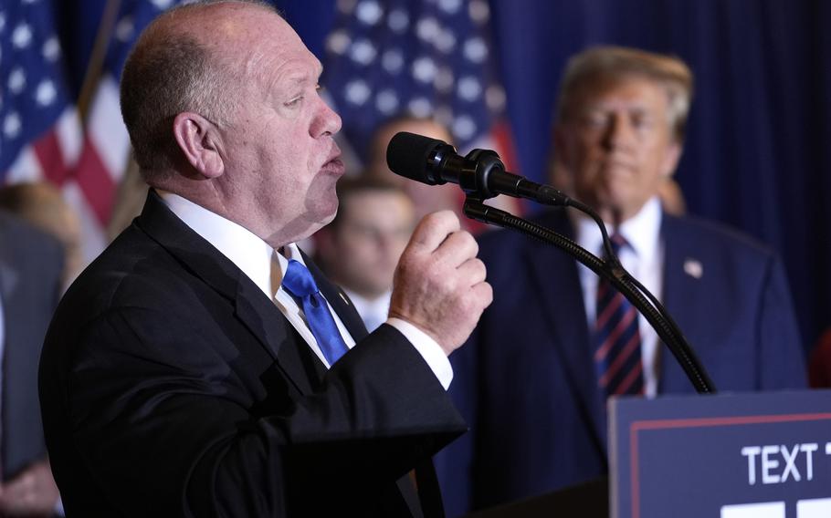 Tom Homan speaks with former President Donald Trump in the background.