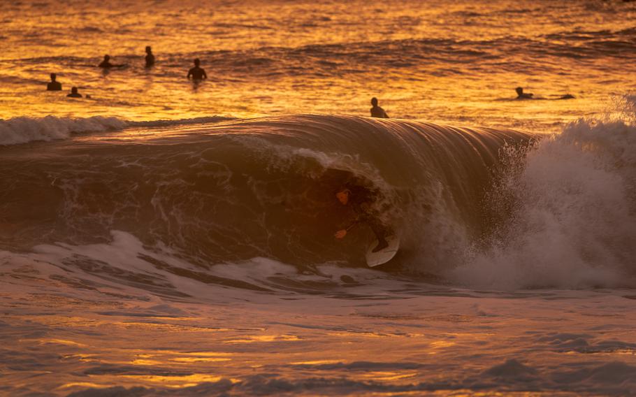 With the golden glow of the sunset, surfer Dylan Sloan, 15, of Huntington Beach, gets a coveted tube ride while surfing big waves generated by winter storms at the Seal Beach pier in January.