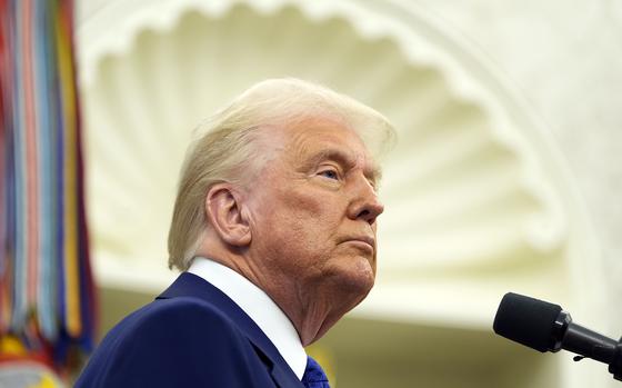 President Donald Trump stands in front of a microphone.