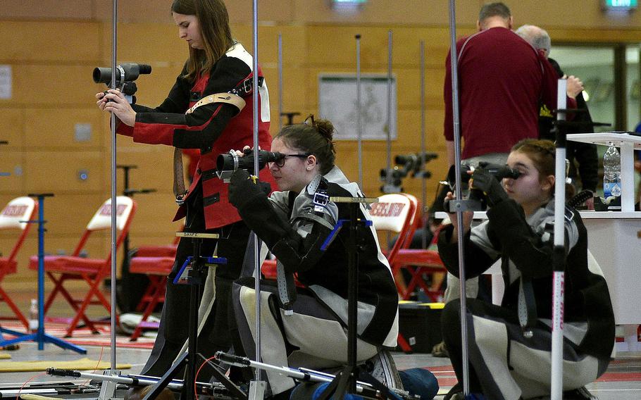 Baumholder's Ashlyn Brech, left, adjusts her sight while SHAPE's Marina Dimou, center, looks through hers in kneeling position during a marksmanship competition on Jan. 6, 2024, at Kaiserslautern High School in Kaiserslautern, Germany.