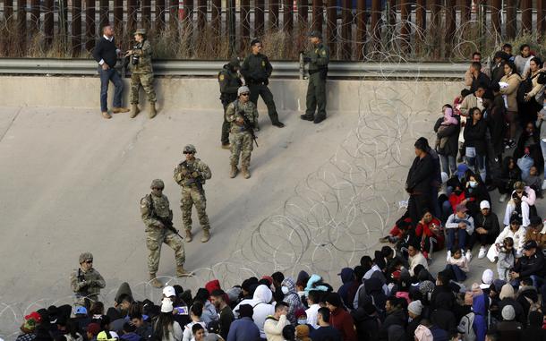 FILE - Migrants congregate on the banks of the Rio Grande at the U.S. border with Mexico on Dec. 20, 2022, where members of the Texas National Guard cordoned off a gap in the U.S. border wall. (AP Photo/Morgan Lee)