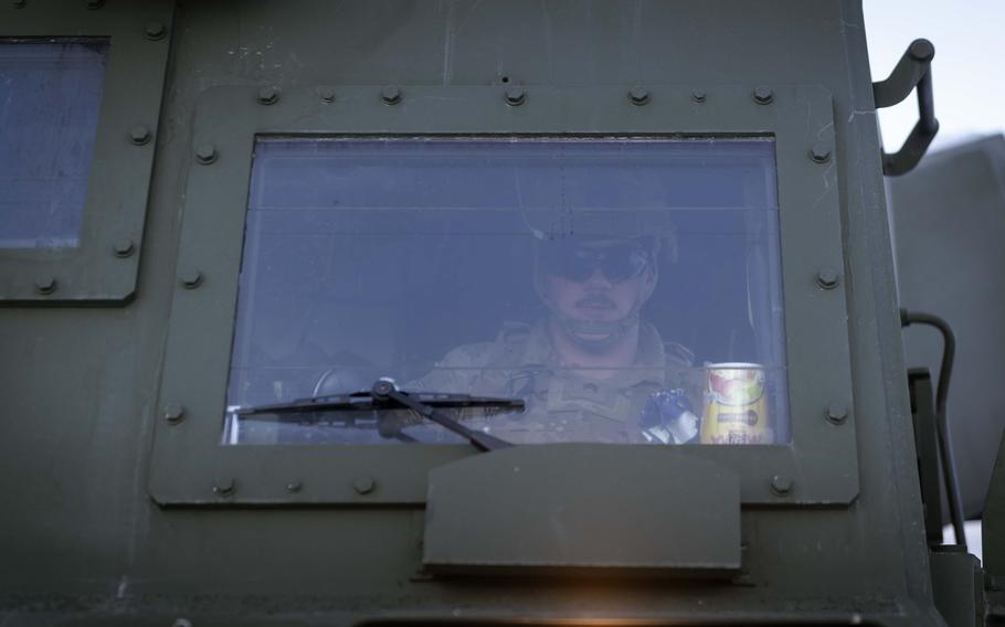 A driver sits in the cab of an MLRS