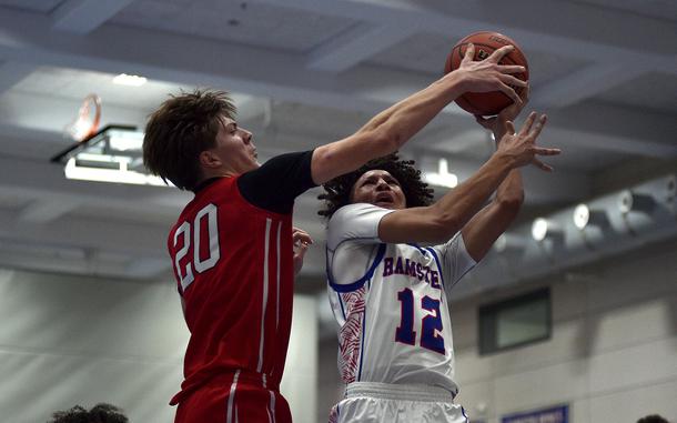 Kaiserslautern's Garrett Vitter blocks a shot by Ramstein's Awwab Noble during a Dec. 10, 2024, game at Ramstein High School on Ramstein Air Base, Germany.