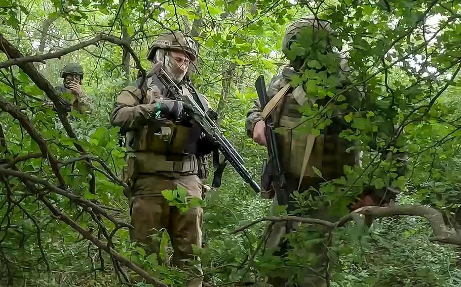 Russian soldiers walk through a forest in an undisclosed location in Ukraine.