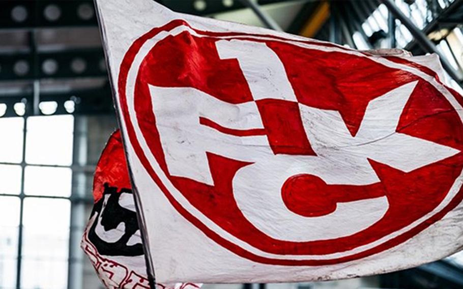 A 1FCK Kaiserslautern flag flies at a soccer game.