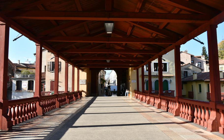 The path of the Ponte Vecchio covered bridge and its roof extend from the perspective of the inside in Bassano del Grappa, Italy.