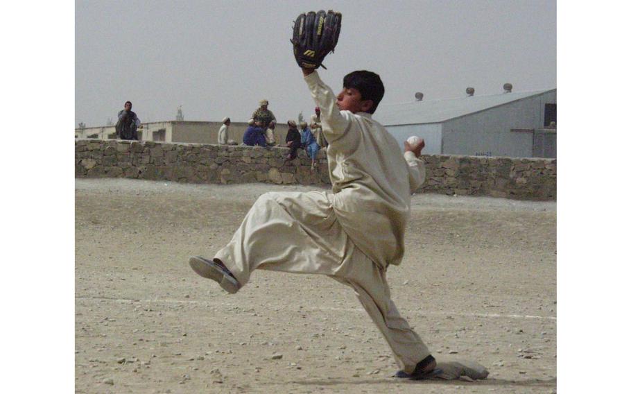 Nasib, 14, fires a pitch during the fourth inning in Orgun-e, Afghanistan. U.S. soldiers have put together two baseball teams with local boys, holding games each Friday.