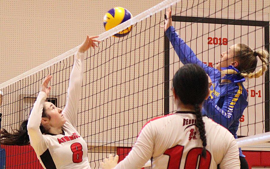 Yokota's Claire Smith and Nile C. Kinnick's Isabella Marchetti go for the ball at the net during Saturday's DODEA-Japan/Kanto Plain volleyball match. The Red Devils won in four sets.