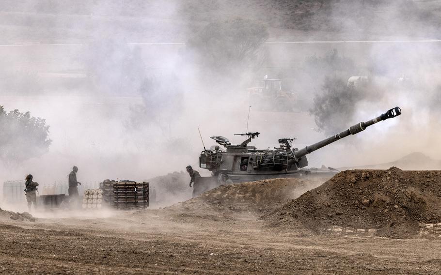 Israeli forces fire a howitzer toward Gaza near the border on Oct. 27, 2023. 