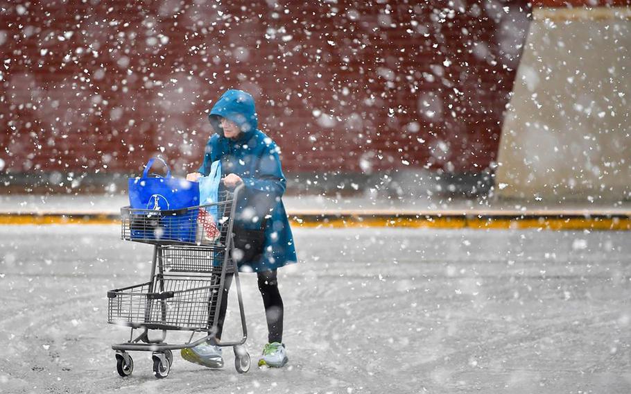 Snow falls as a shopper heads to the parking lot of a grocery store in Shawnee, Kansas, on Jan. 8, 2024. Snow and cold temperatures are expected across the country this weekend. (Tammy Ljungblad/TNS)