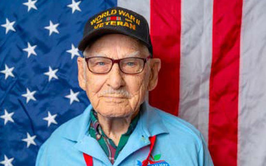 World War II veteran John Hodges stands in front of a U.S. flag.