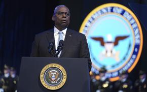 Lloyd Austin stands at a podium that reads, “Seal of the president of the United States.”