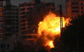 A fiery explosion erupts in front of a multi-story building in Lebanon.