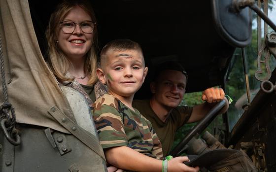 Tom Verbrugge, right, his nephew Livio, and girlfriend Valentine Simon take part in the Tanks in Town parade in Mons, Belgium, Sunday, Sept. 1, 2024.