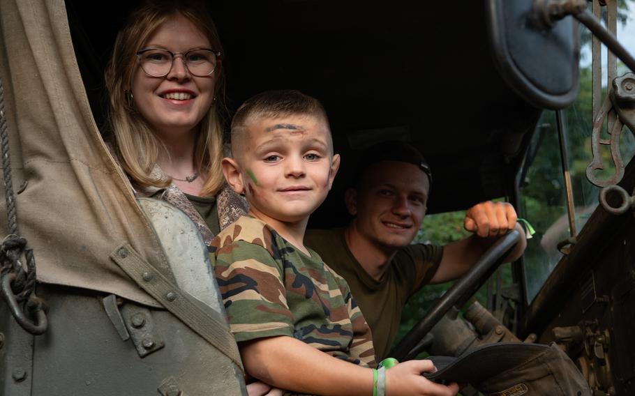 Belgians ride in a tank as part of the tanks in town parade in mons, belgium