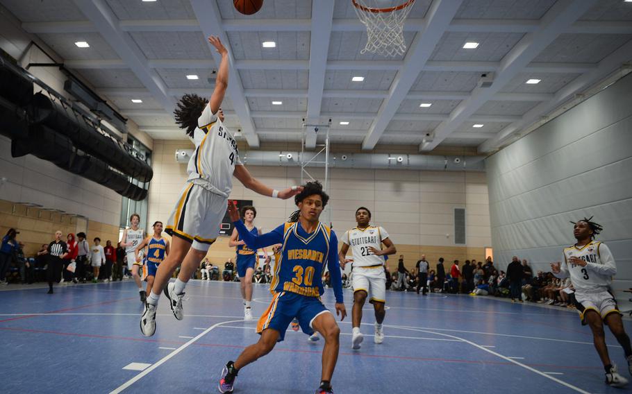Stuttgart's Ismael Anglada-Paz jumps for a layup against Wiesbaden's Malfoy Anitok during the Division I boys basketball championships at Ramstein Air Base in Germany on Feb. 16, 2023.