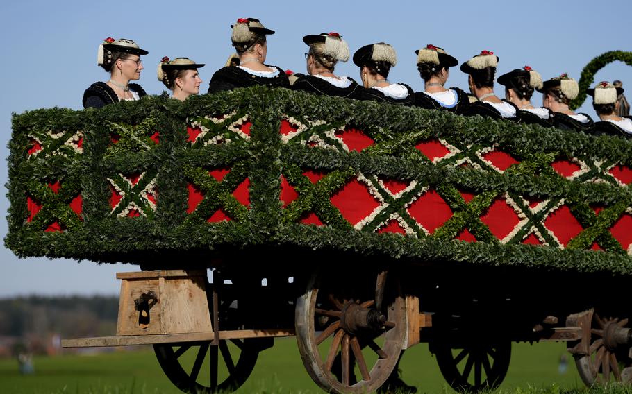 People in horse-drawn carriages and costumes take part in a pilgrimage in the German countryside.