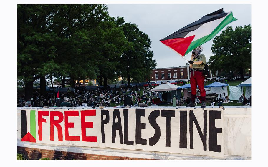 A demonstrator waves a Palestinian flag in front of a few hundred students protesting the Israel-Gaza war Tuesday, at Johns Hopkins University’s Homewood Campus in Baltimore. 