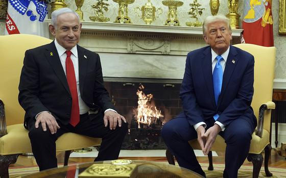 Donald Trump and Benjamin Netanyahu sit in chairs in front of a fireplace in the Oval Office of the White House.