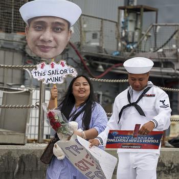 Personnel Specialist 2nd Class Joshua Arellano walks down the pier with his wife after the USS Leyte Gulf returned to Naval Station Norfolk on May 17, 2024, following its final deployment.