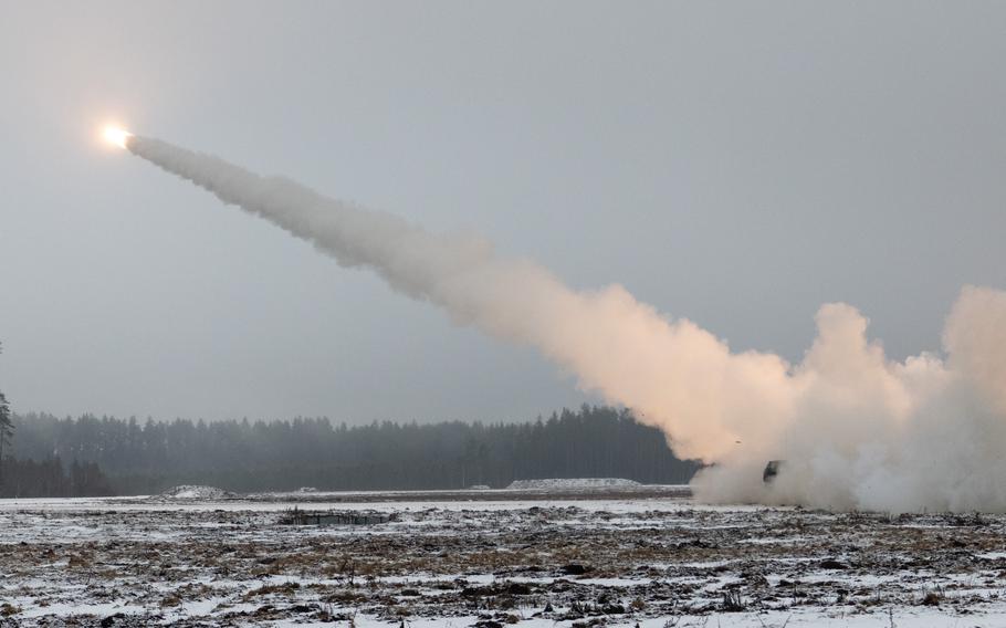 Smoke rises after a HIMARS is fired in a snowy field.