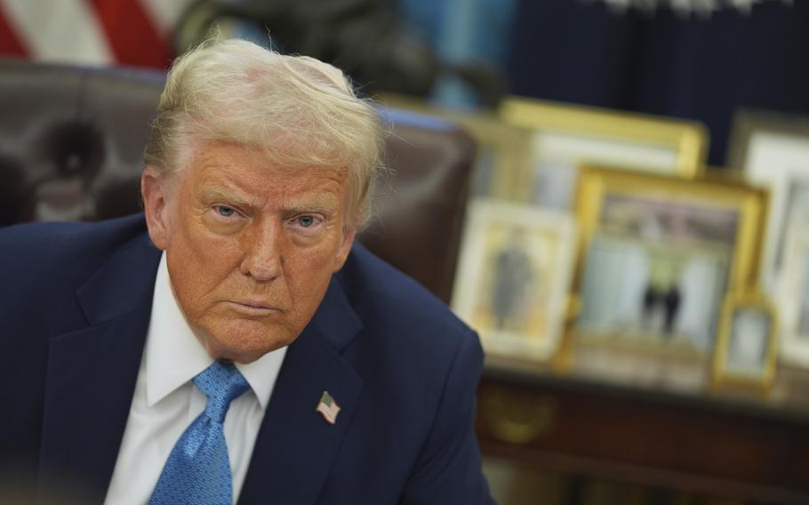 A close-up of President Trump in a blue tie looking at the camera.