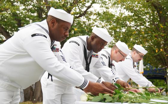 Sailors lay flowers in memory of deceased service members during the Bells Across America ceremony at Yokosuka Naval Base, Japan, Thursday, Sept. 19, 2024.