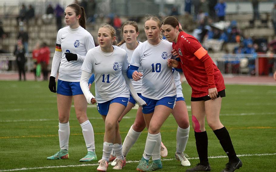 Players line up before a corner kick.