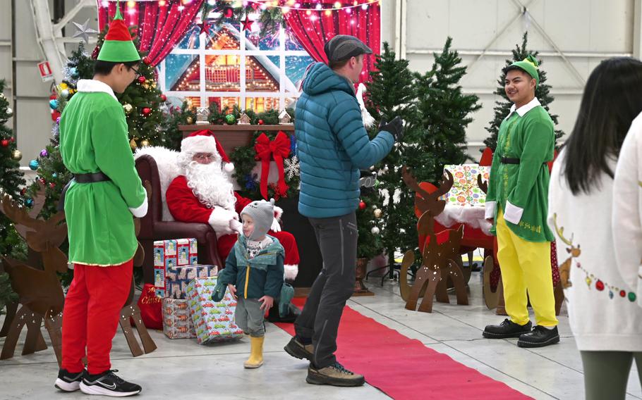 Santa, his elves and children at Christmas celebration.