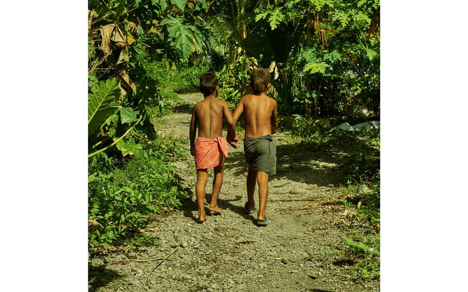 Two boys from Fais Island take the main road to the village chief’s house Dec. 8, 2015.